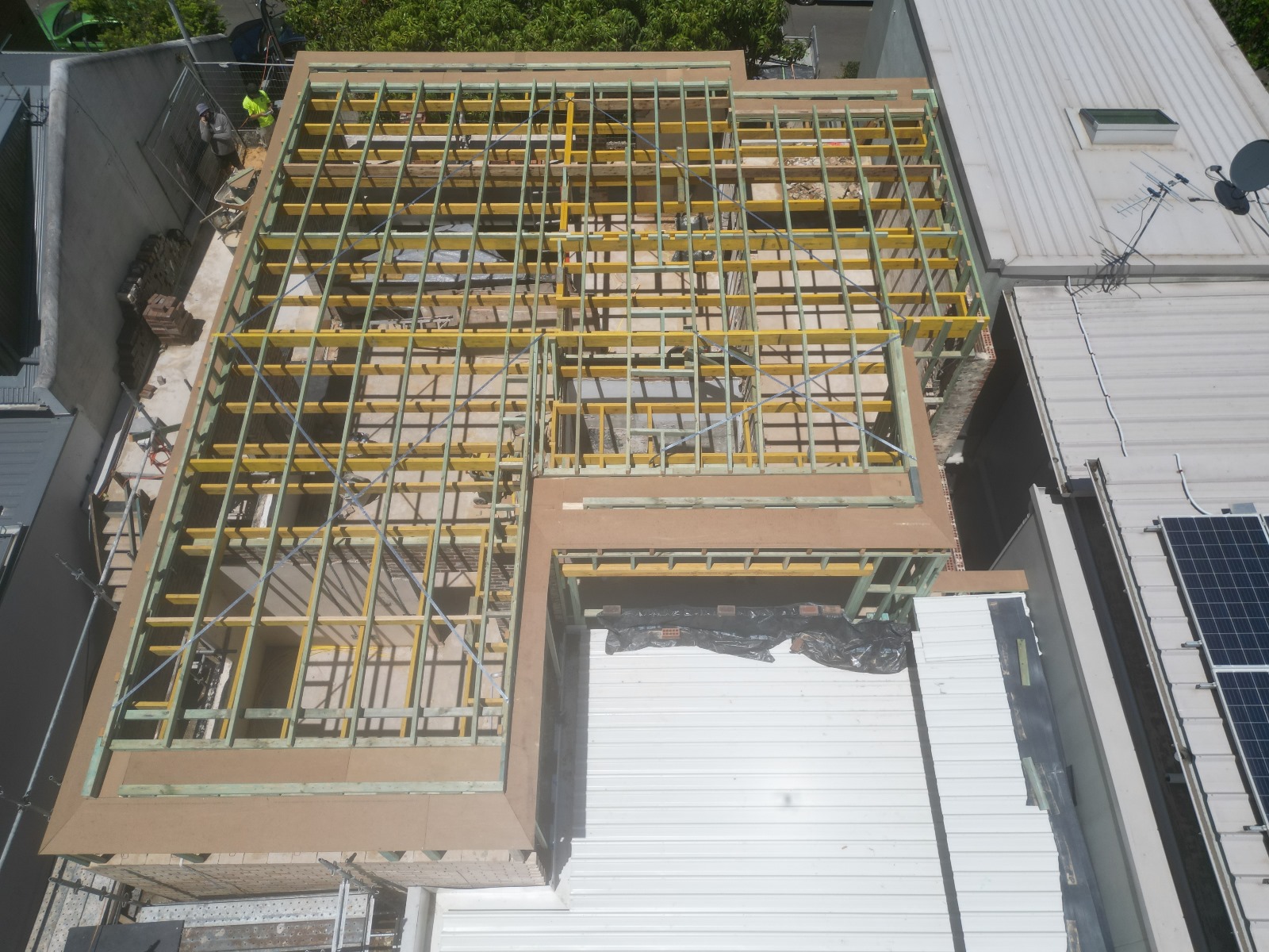 Steel floor framing photographed from directly above, reading as a floor plan.