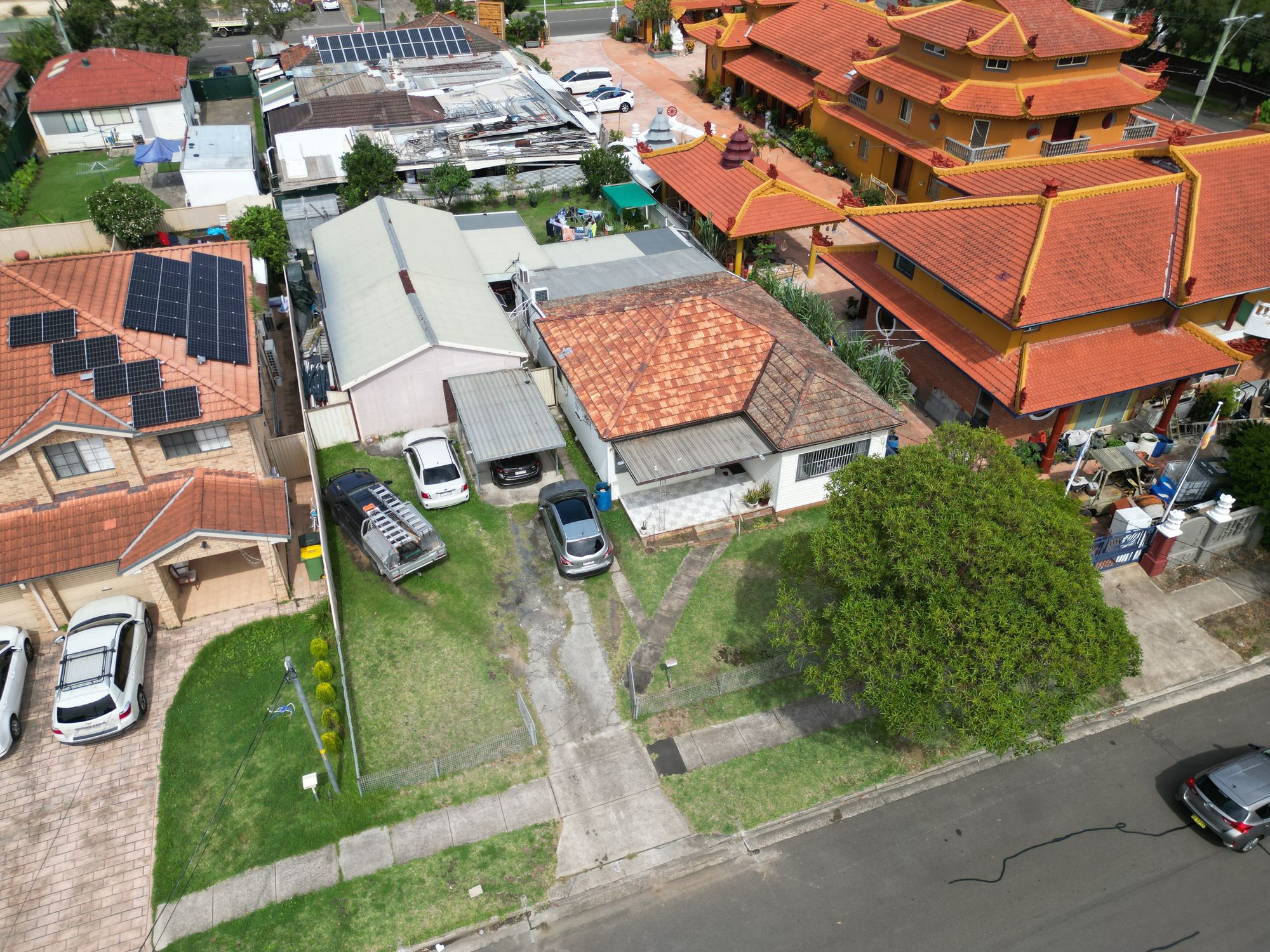 Aerial view of the block before work starts: two existing dwellings, driveways and neighbouring houses hard against both boundaries.